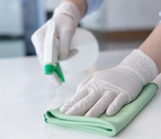 imgi_25_Sanitizing+countertop+-+Cleaning+surfaces+-+Cleaning+service+-+Spray+bottle+and+cleaning+cloth+and+gloved+hand+-+Indoor+kitch